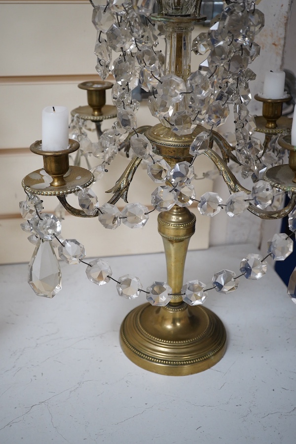 A pair of brass four branch candelabra with glass drops, 61cm high. Condition - fair
